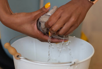 hands wringing out mop water and hand mopping